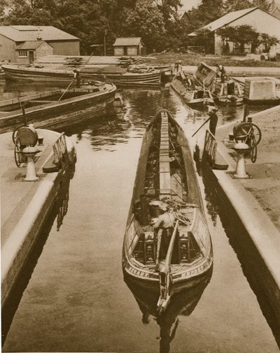 Pushing a monkey boat through a lock at Brentford by English Photographer